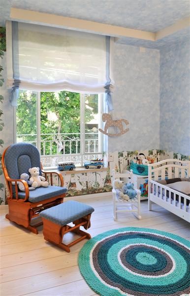 Фотография дизайна детской комнаты с голубыми стенами.