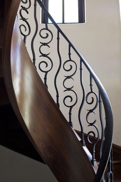 Фотография современной лестницы с кованными перилами.