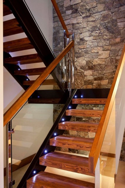Интерьер лестницы со стеклянными перилами.