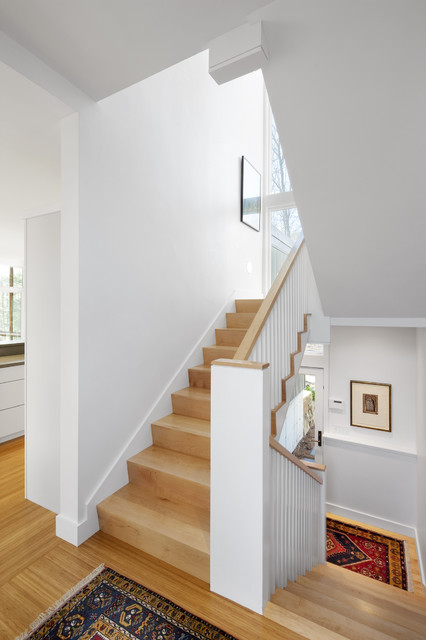 Интерьер  традиционной деревянной лестницы в белом.