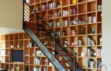 Фото лестницы у книжной стены-полки